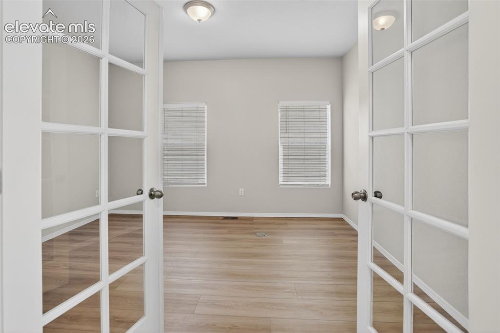 Image 8 of 49: Double French doors with frosted glass panels open into a room featuring wo