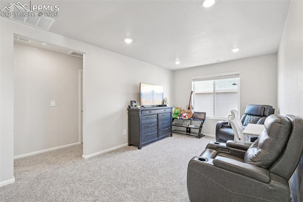Image 18 of 34: Living room featuring light colored carpet and recessed lighting