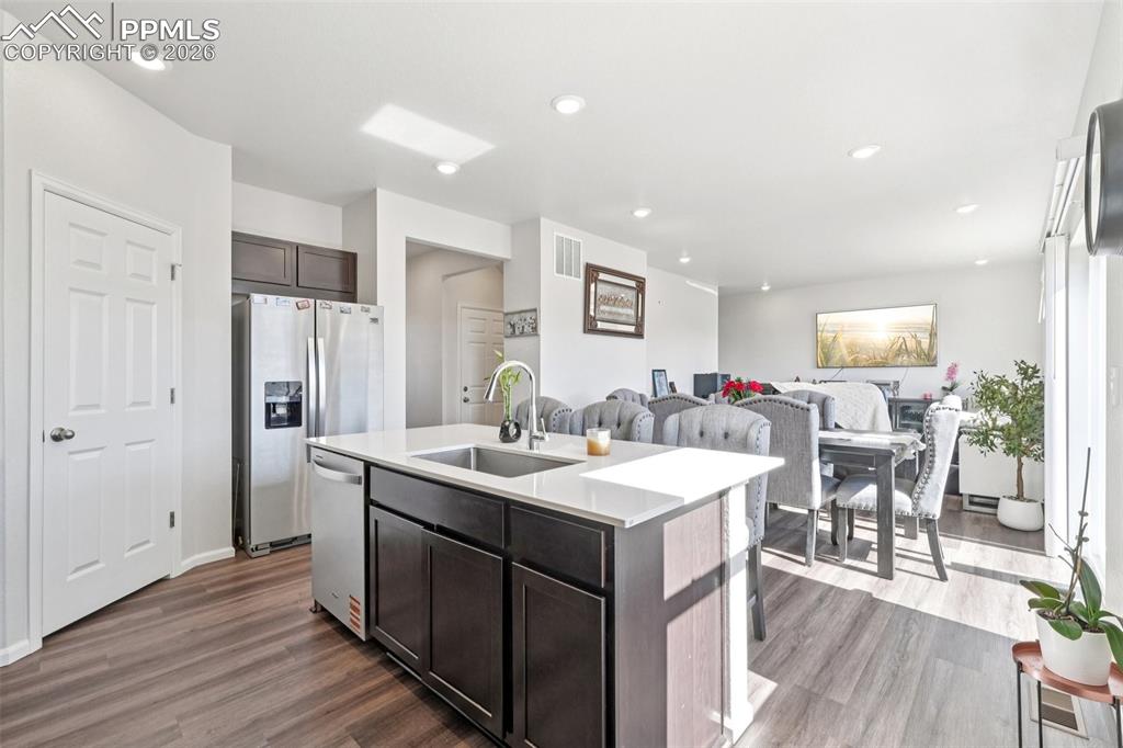 Image 2 of 34: Kitchen with open floor plan, dark wood finish cabinets, stainless steel ap