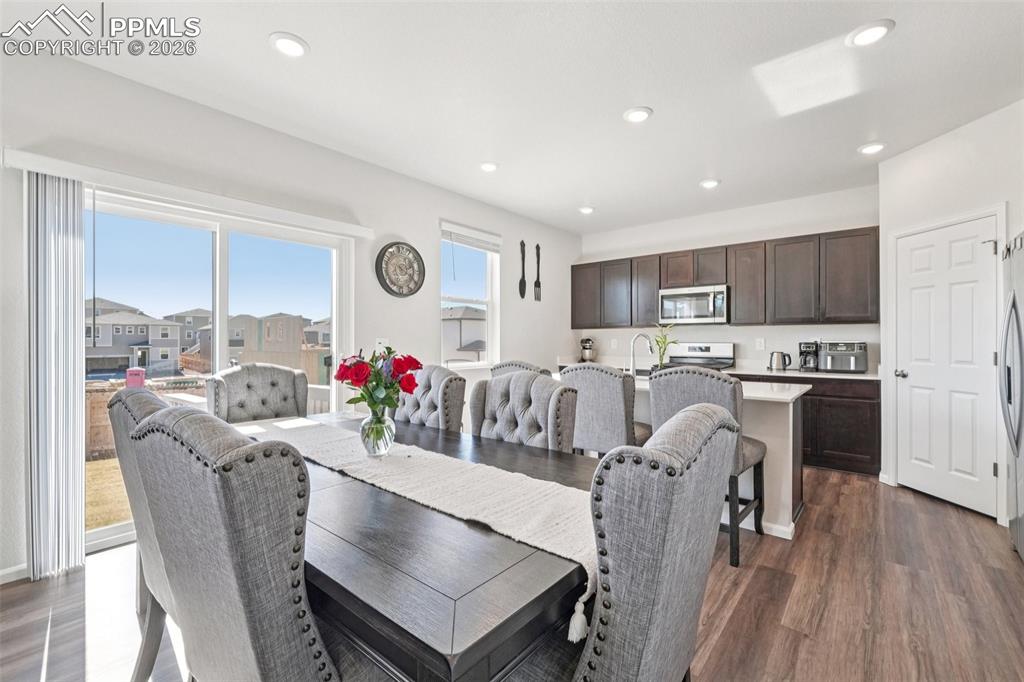 Image 8 of 34: Dining room with dark wood-style flooring and recessed lighting