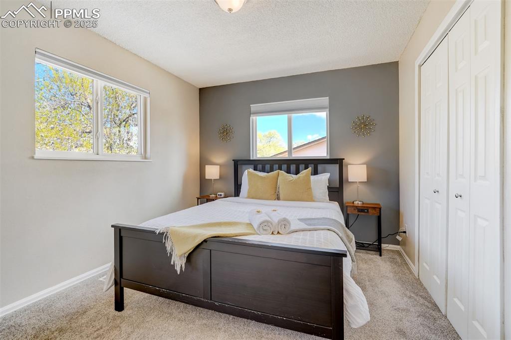 Image 12 of 25: Bedroom with carpet, a closet, and a textured ceiling