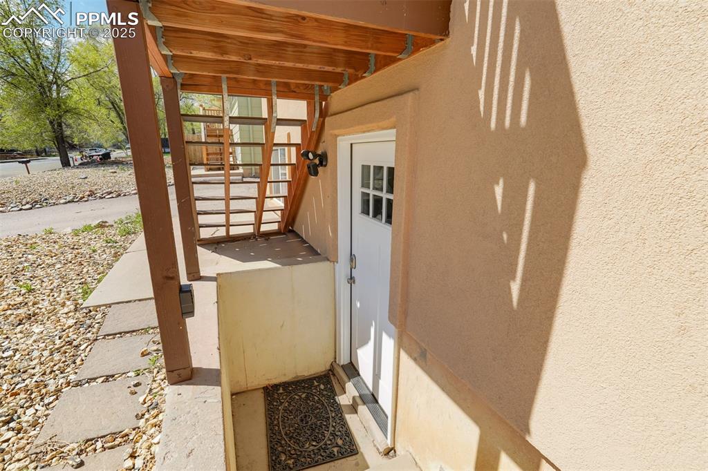 Image 18 of 25: View of exterior entry featuring stucco siding