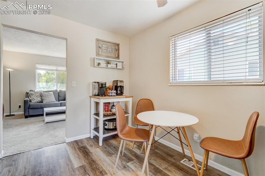 Image 9 of 25: Dining area with light wood-type flooring and ceiling fan