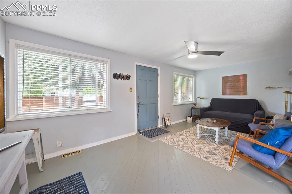 Image 11 of 36: Living area featuring baseboards, wood-type flooring, visible vents, and a