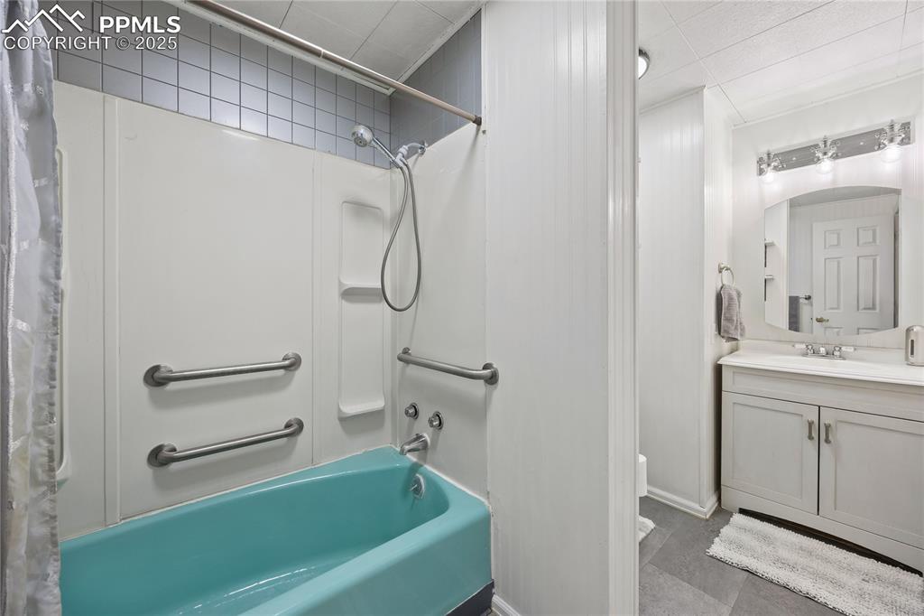Image 20 of 36: Full bath with crown molding, vanity, and shower / bath combo with shower c