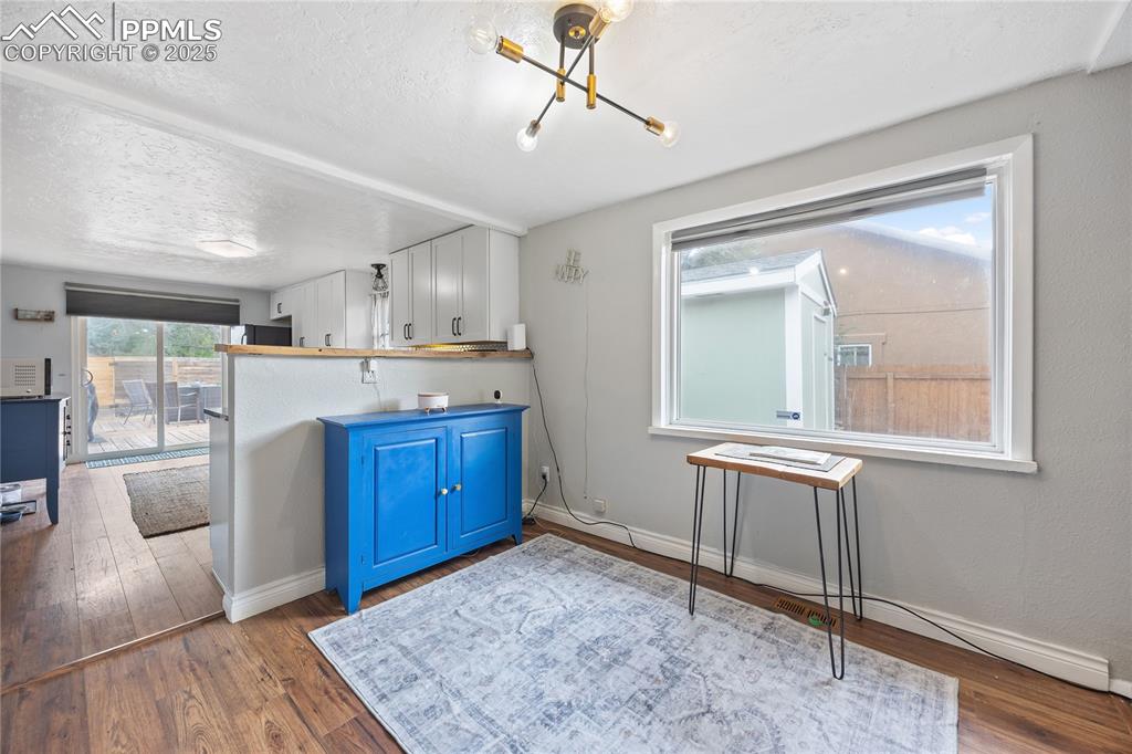 Image 22 of 36: Kitchen with baseboards, a textured ceiling, blue cabinetry, and wood finis