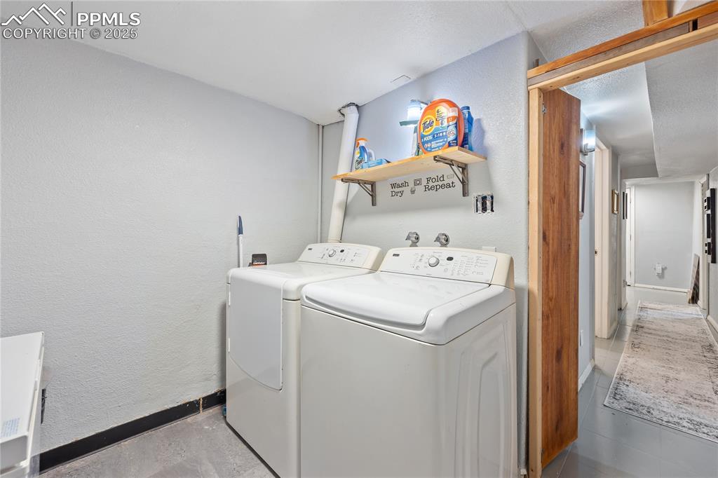 Image 31 of 36: Washroom featuring laundry area, baseboards, separate washer and dryer, and