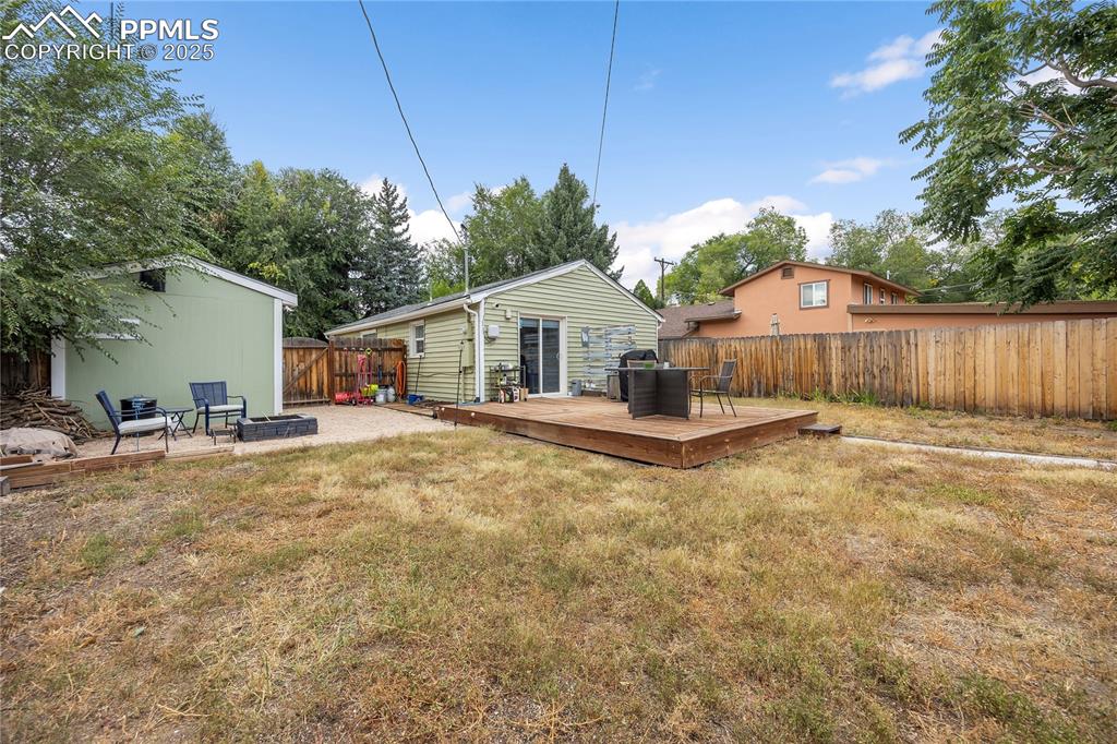 Image 34 of 36: View of yard featuring a fenced backyard, an outbuilding, and a wooden deck