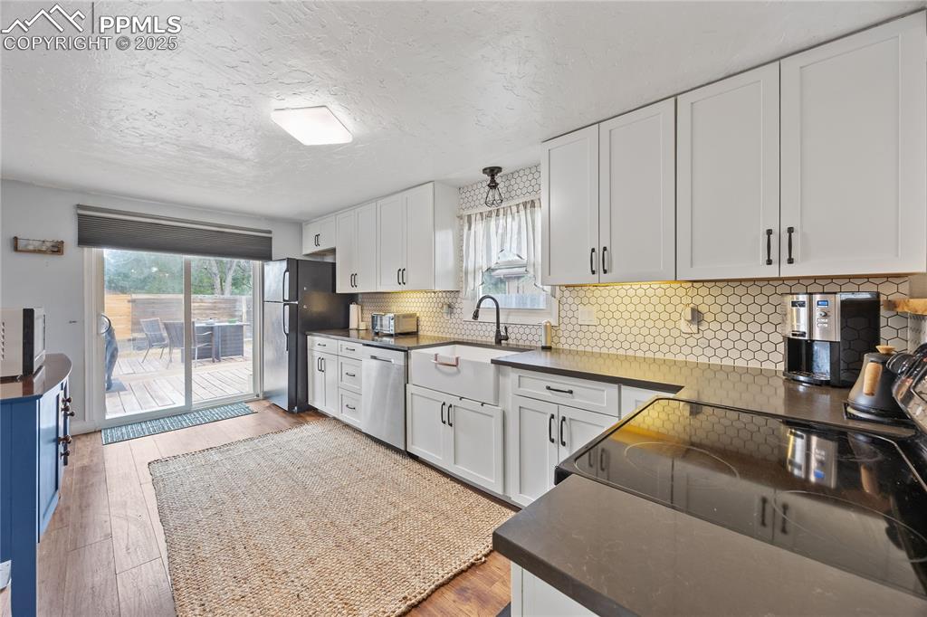 Image 6 of 36: Kitchen with dark countertops, appliances with stainless steel finishes, wh