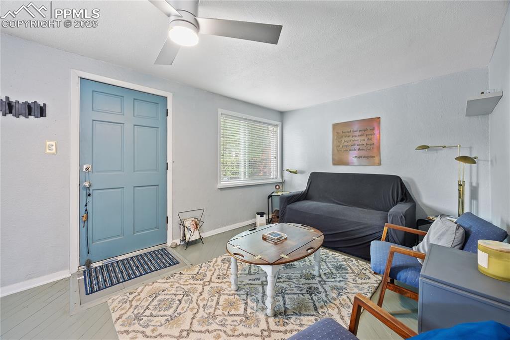 Image 9 of 36: Living area featuring ceiling fan, baseboards, and wood finished floors