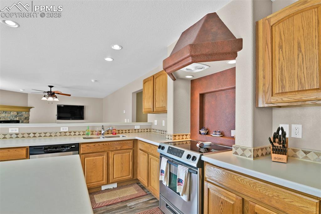 Image 15 of 50: Kitchen with appliances with stainless steel finishes, light countertops, p