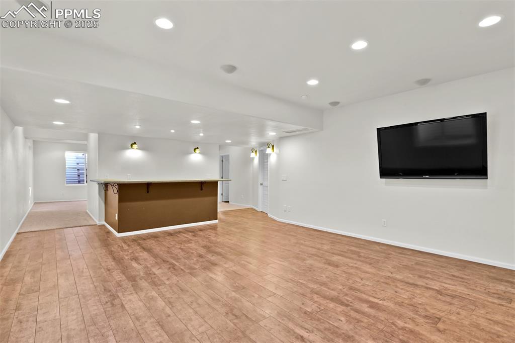 Image 36 of 50: Living Room in Basement w/ Bar and Television