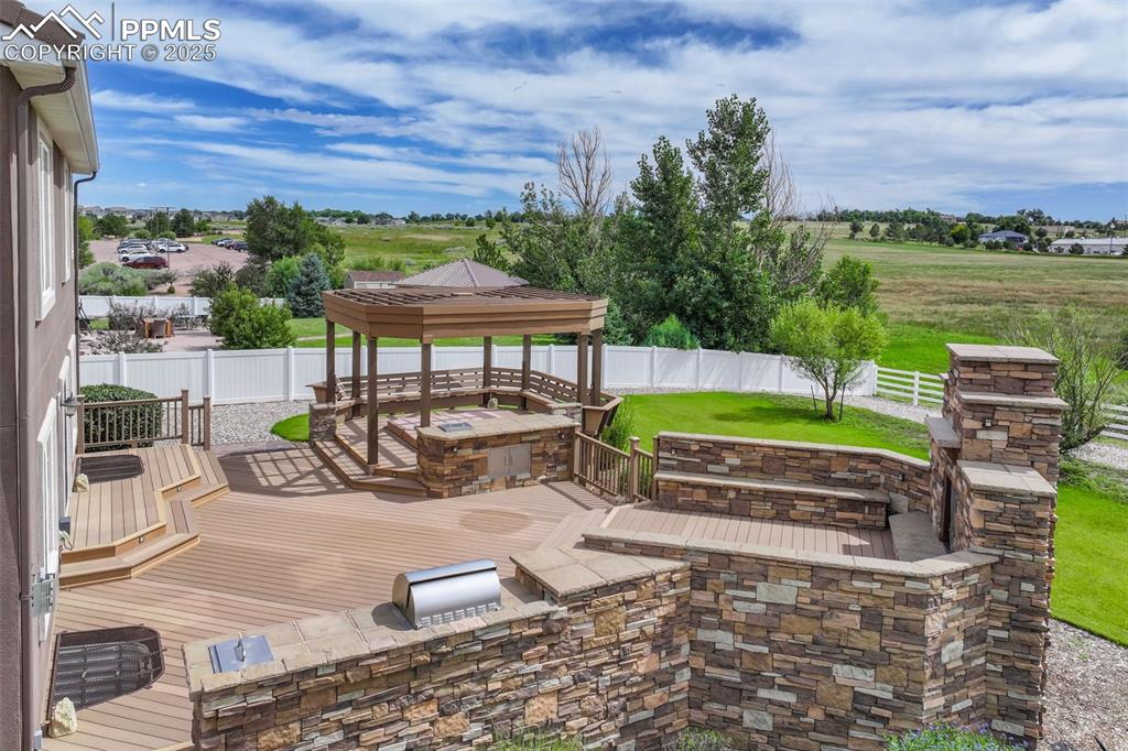Image 48 of 50: Fenced backyard featuring a gazebo, area for grilling, and a deck