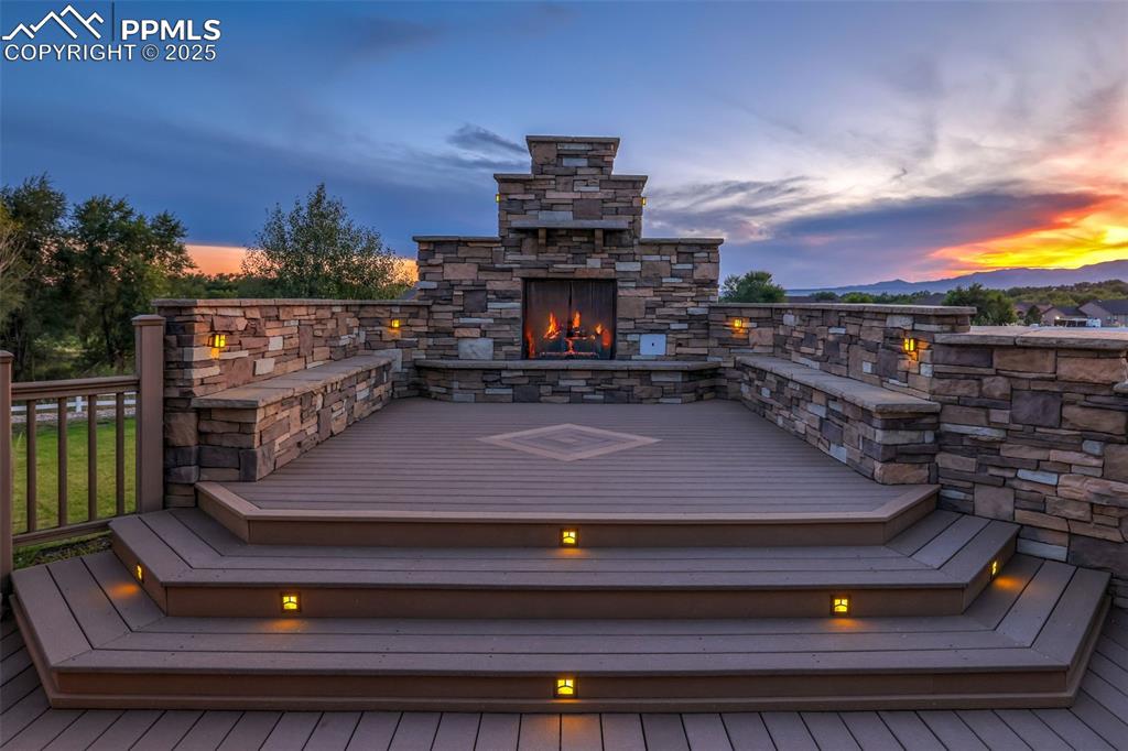 Image 5 of 50: Deck with an Outdoor Stone Fireplace.