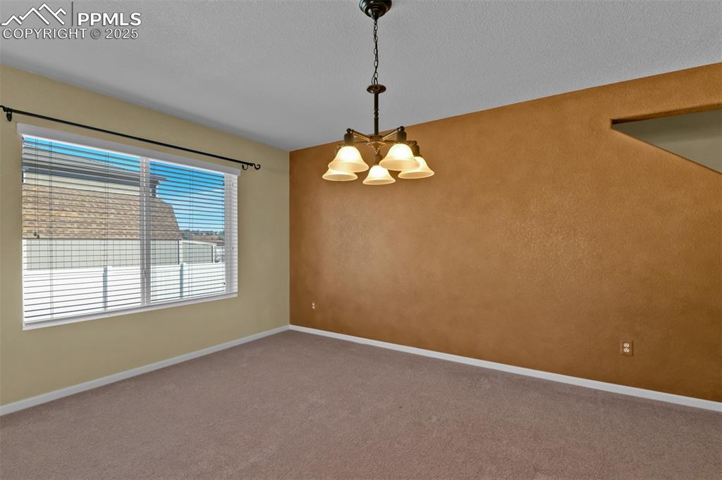 Image 8 of 50: Empty room with carpet flooring, a chandelier, and a textured ceiling