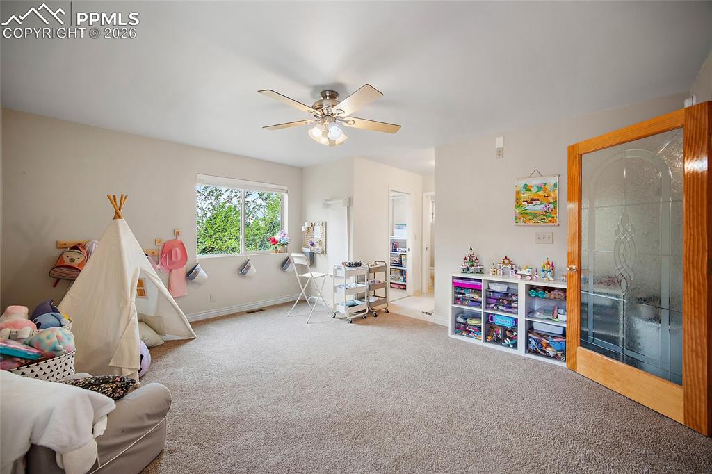 Image 13 of 47: Main level primary suite, currently utilized as a playroom