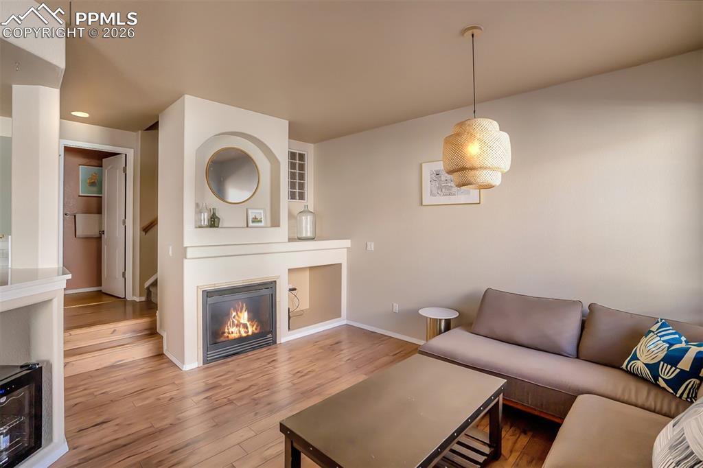 Image 11 of 26: Gas fireplace and 1/2 Guest Bath at top of the 2 stairs.