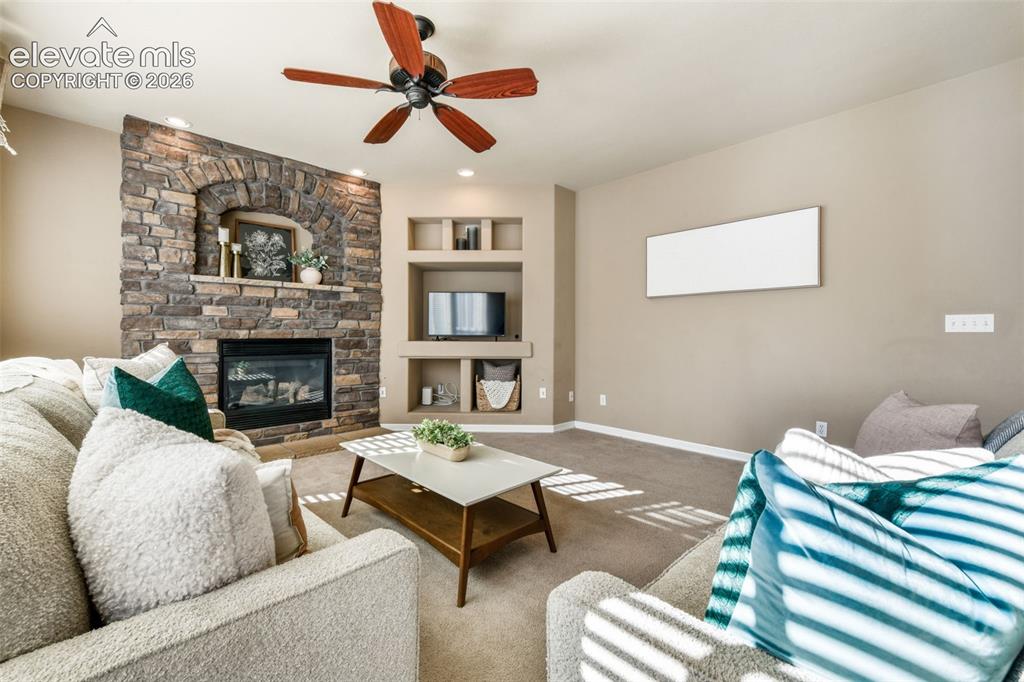 Image 10 of 50: Stone-clad fireplace with an arched opening and mantel