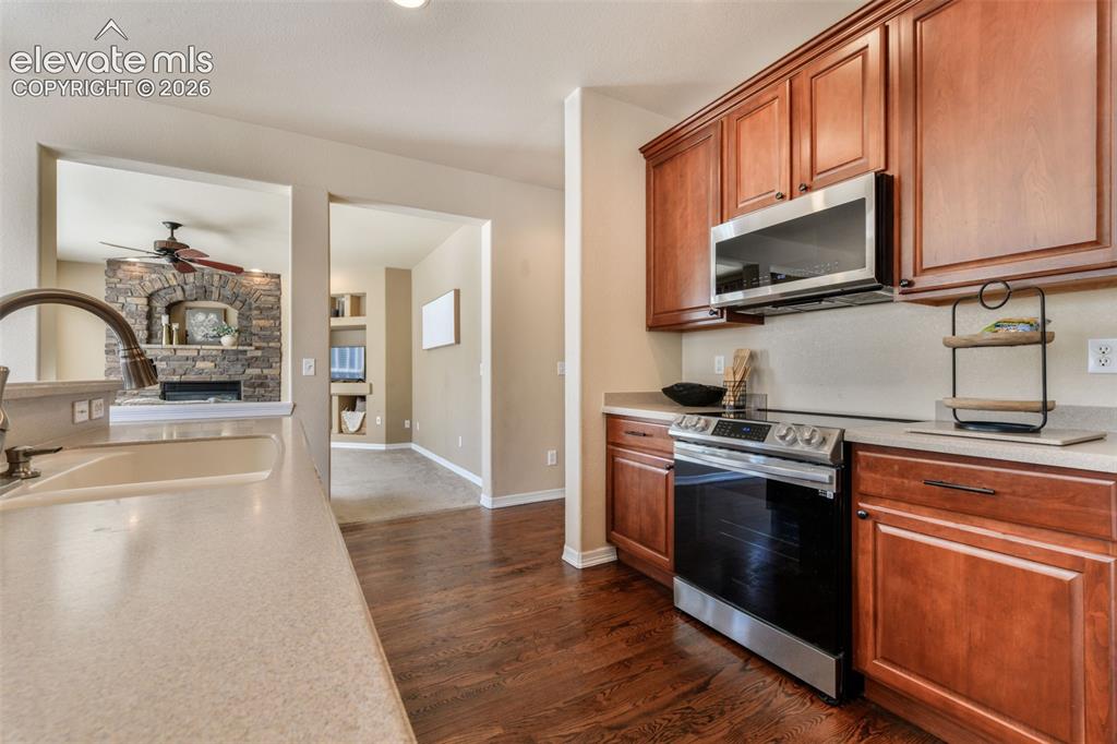 Image 12 of 50: Well-appointed kitchen featuring wood-finish flooring, cherry-toned cabinet