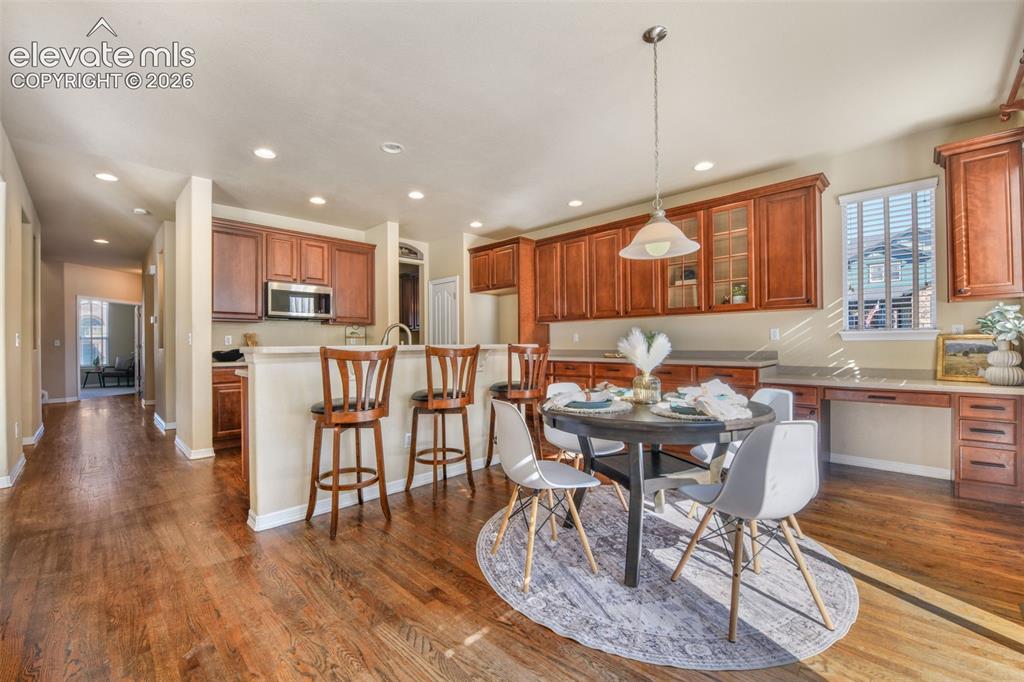 Image 13 of 50: Wood-finish flooring throughout, kitchen with wood cabinetry, stainless ste