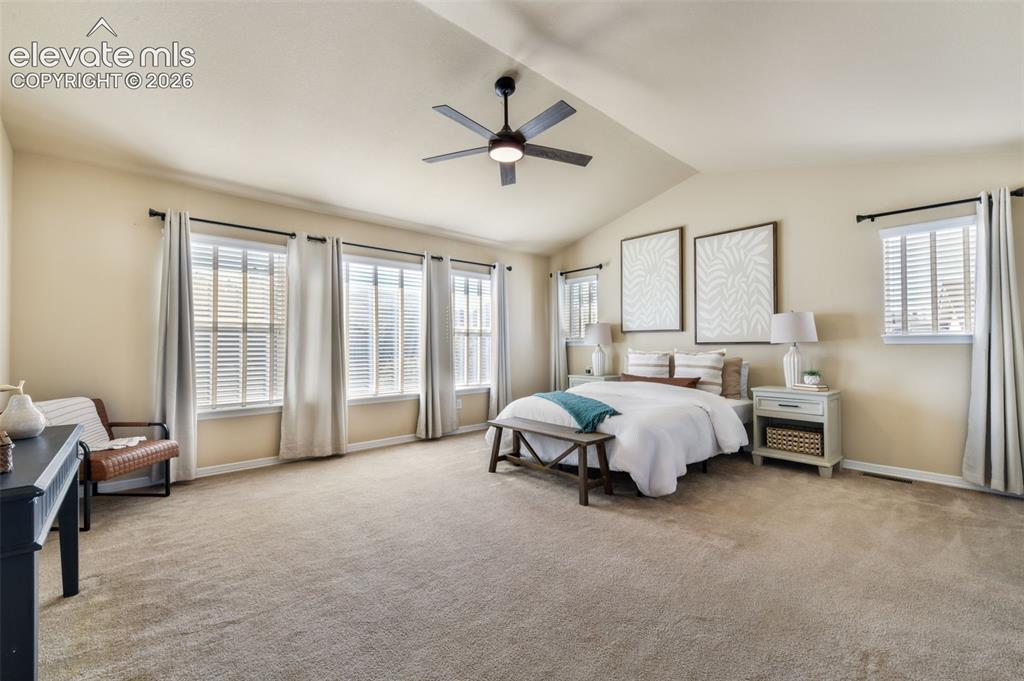 Image 19 of 50: Vaulted ceiling with a ceiling fan, five windows with blinds, and neutral c