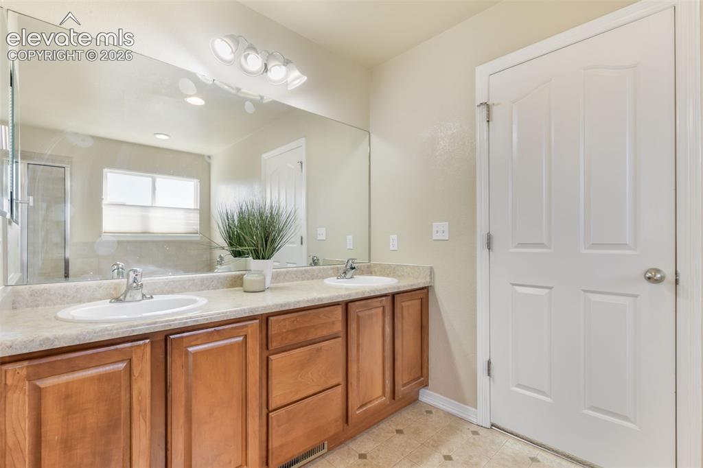 Image 23 of 50: Dual undermount sinks with chrome faucets, wood-finish cabinetry, a large w