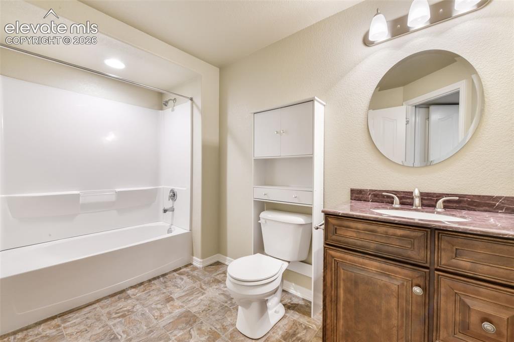 Image 40 of 50: Bathroom featuring a tub/shower combination, dark wood-finish vanity with a