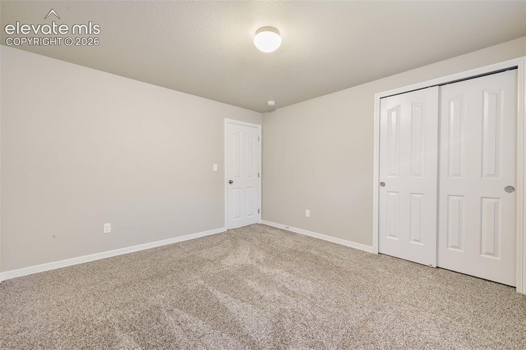 Image 43 of 50: Neutral-toned walls complement the textured carpeting