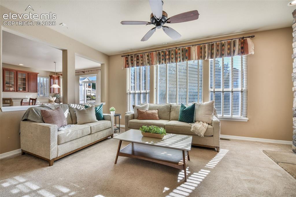 Image 9 of 50: Recessed lighting, ceiling fan with wood-finish blades, and large windows w