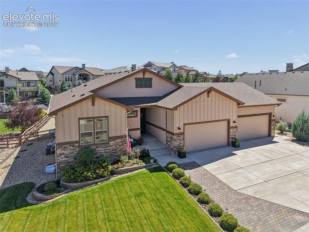 Caption: Exterior featuring stone veneer accents, multi-pane windows, a two-car garage, and an additional sin