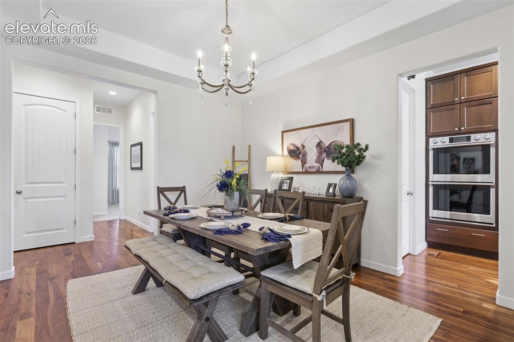 Image 11 of 50: Hardwood flooring, recessed lighting, and a chandelier fixture