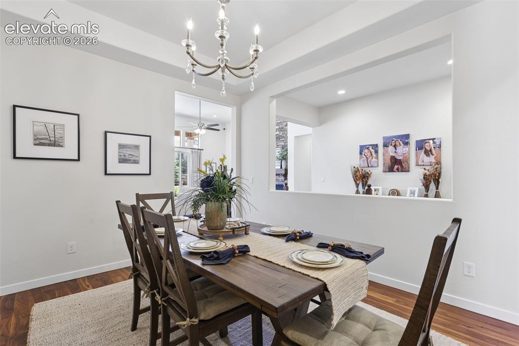 Image 12 of 50: Dining area featuring a wood-finish floor and a crystal chandelier