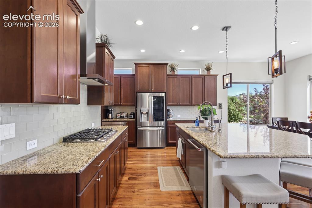 Image 13 of 50: Kitchen featuring wood-finish flooring, recessed lighting, and a kitchen is
