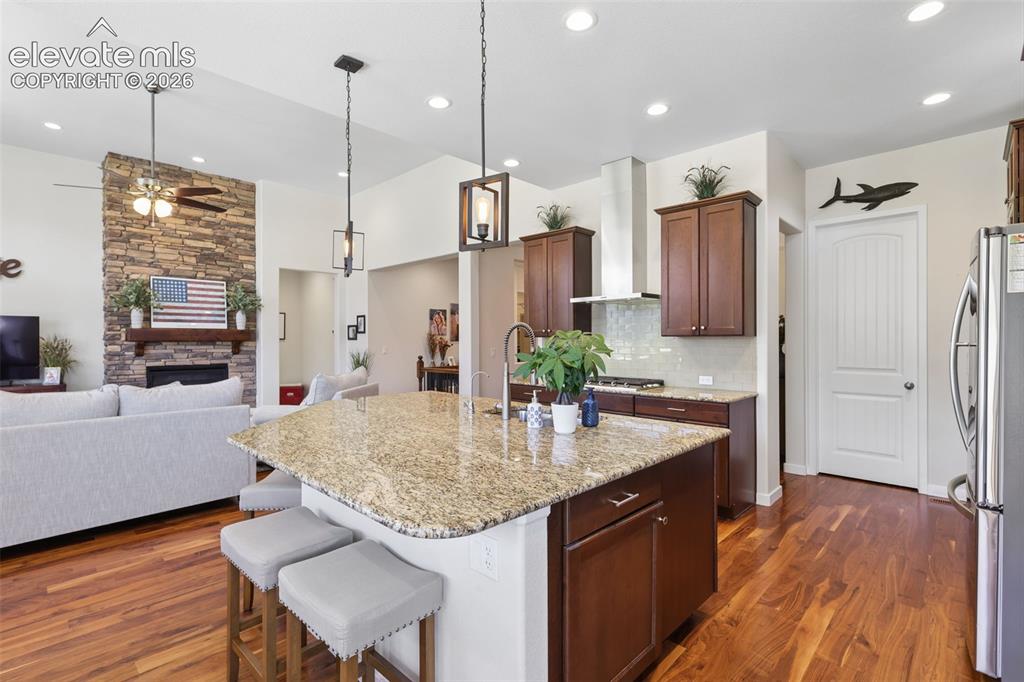 Image 14 of 50: Kitchen featuring a granite-topped island with seating, pendant lighting, s
