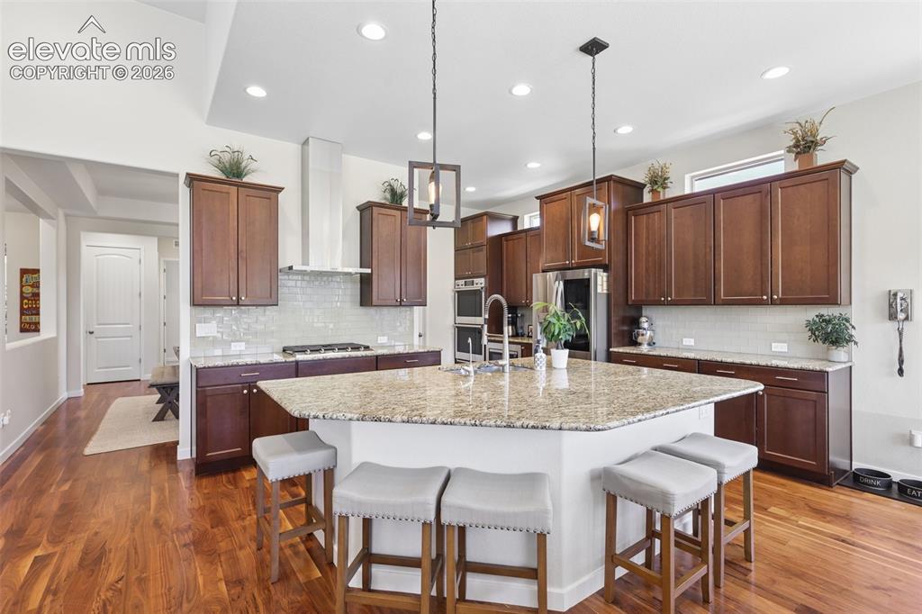 Image 16 of 50: Kitchen featuring rich wood-finish flooring, dark wood cabinetry, a large c