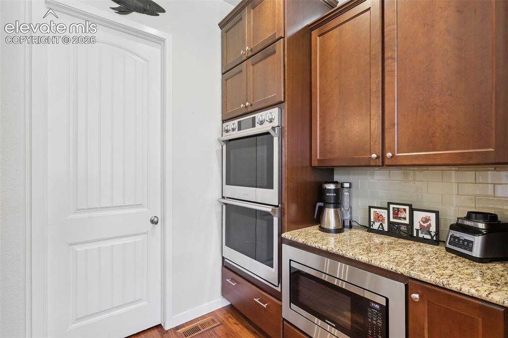 Image 17 of 50: Kitchen featuring wood-finish flooring, stainless steel double wall ovens, 