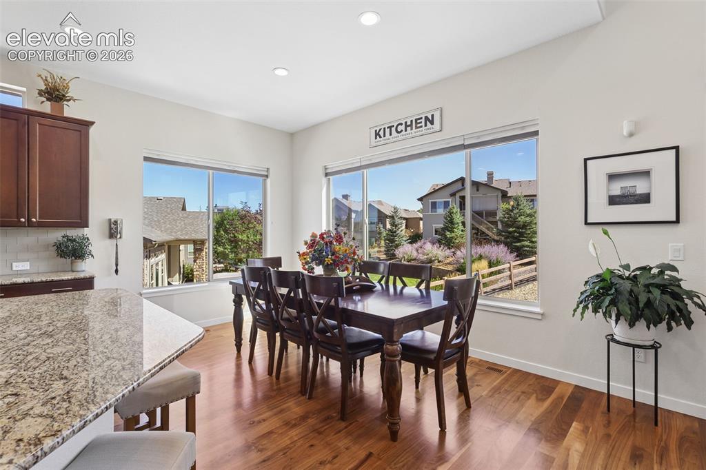Image 18 of 50: Wood-finish flooring, recessed lighting, and large windows