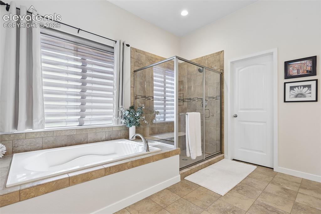 Image 24 of 50: Walk-in shower with clear glass enclosure and tile surround