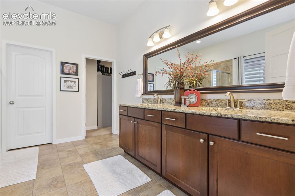 Image 25 of 50: Spa-inspired primary bathroom featuring a dual-sink vanity with wood cabine
