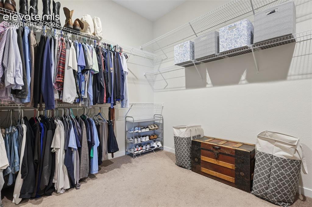 Image 26 of 50: Expansive walk-in closet featuring wire shelving, multiple hanging rods, an