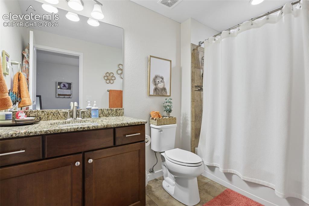 Image 29 of 50: Vanity with granite-style countertop, undermount sink, and wood-finish cabi