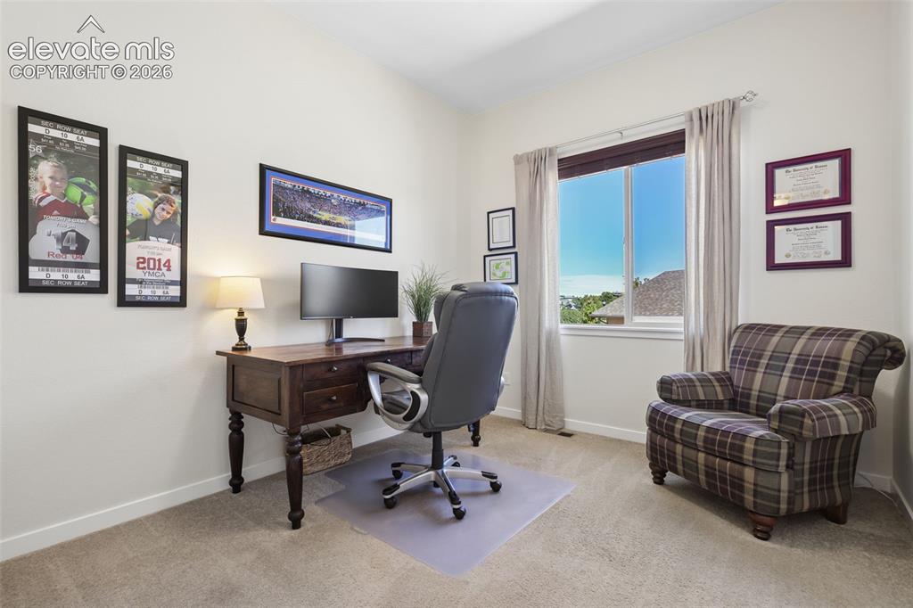 Image 31 of 50: Bright home office featuring a wood-finish desk with turned legs, upholster