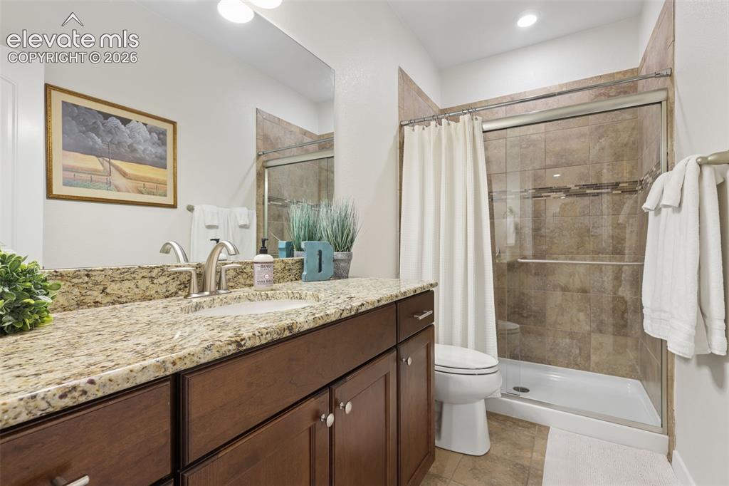 Image 39 of 50: Extended vanity with a granite countertop, undermount sink, and brushed nic