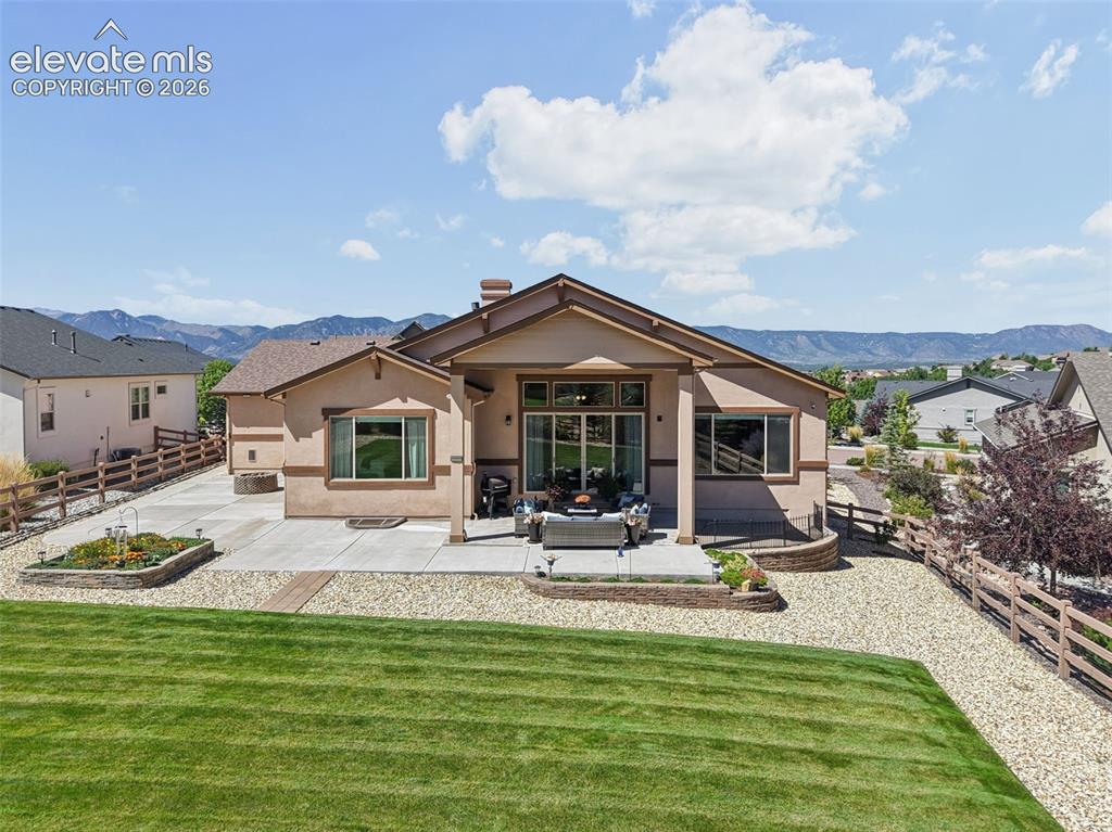 Image 5 of 50: Expansive backyard with a manicured lawn, concrete patio, gravel hardscapin
