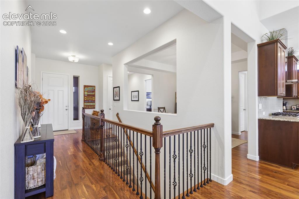 Image 7 of 50: Hardwood-finish flooring throughout, featuring a staircase with wrought iro