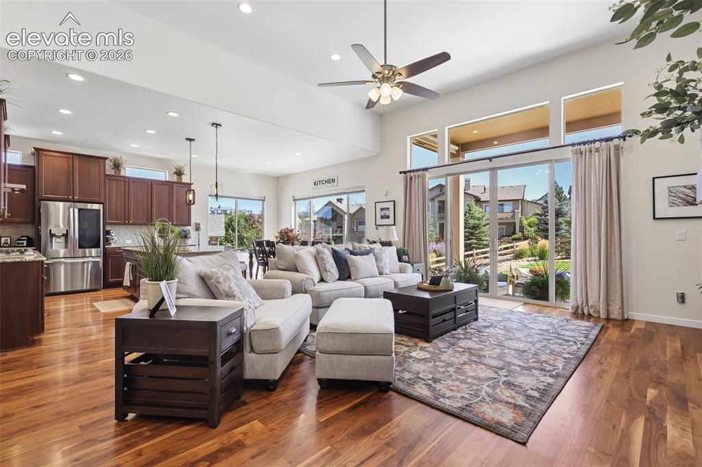 Image 8 of 50: Vaulted ceiling with recessed lighting, wood-finish flooring, full-height s