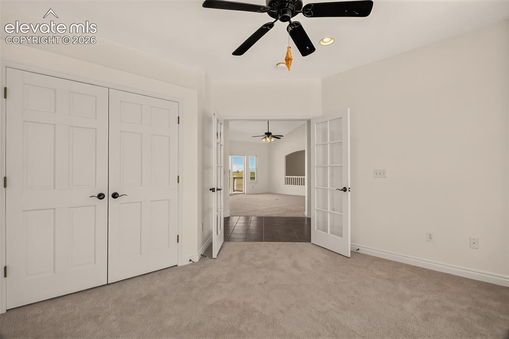 Image 16 of 50: Main Level Office w/Closet And French Doors Looking Into The Great Room