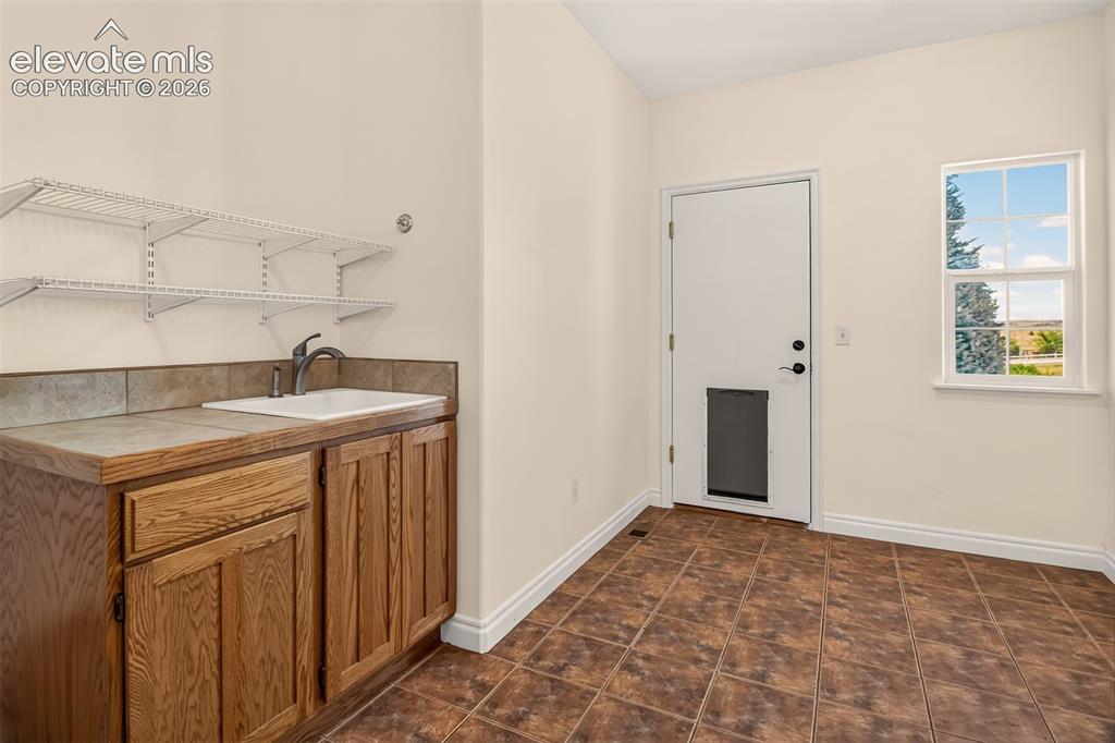Image 36 of 50: Main Level Laundy Sink/Counter, Door To The Garage Is Pet Friendly