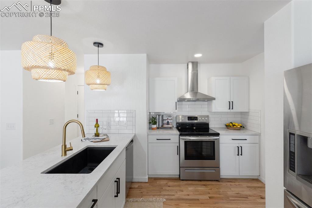 Image 13 of 36: Kitchen featuring appliances with stainless steel finishes, decorative ligh