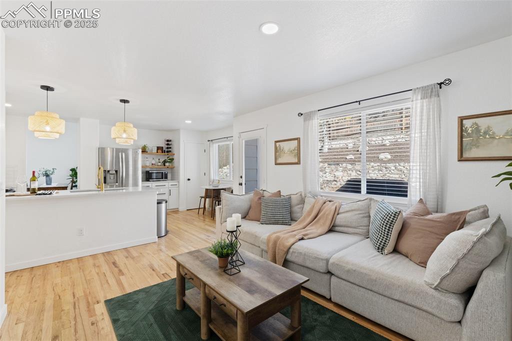 Image 16 of 36: Living room with light wood finished floors and recessed lighting
